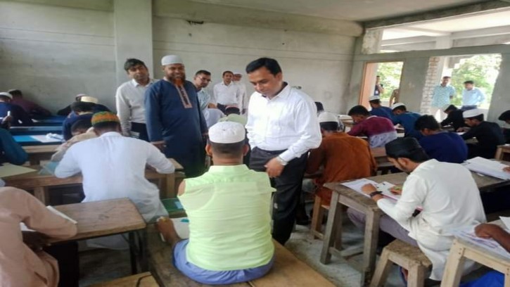 পা দিয়ে লিখে দাখিল পরীক্ষা দিচ্ছেন রাসেল মৃধা